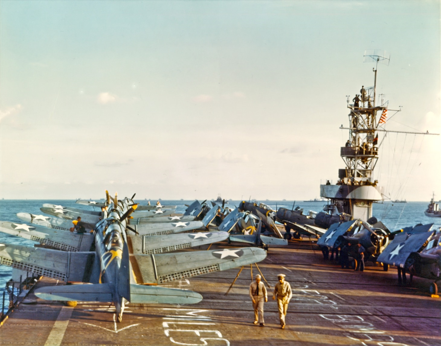 USS Santee (ACV-29)  Douglas SBD-3 Dauntless scout-bombers and Grumman F4F-4 Wildcat fighters on the ship's flight deck during Operation Torch, the November 1942 invasion of North Africa. Note the yellow Operation Torch markings visible around the fuselage stars of some of these airplanes. Also note the distance and target information temporarily marked on the carrier's flight deck. Photographed by Lieutenant Horace Bristol, USNR.  Some published sources state that this photo was taken on USS Sangamon (ACV-26). However, the camouflage pattern on her island definitely identifies the ship as Santee.