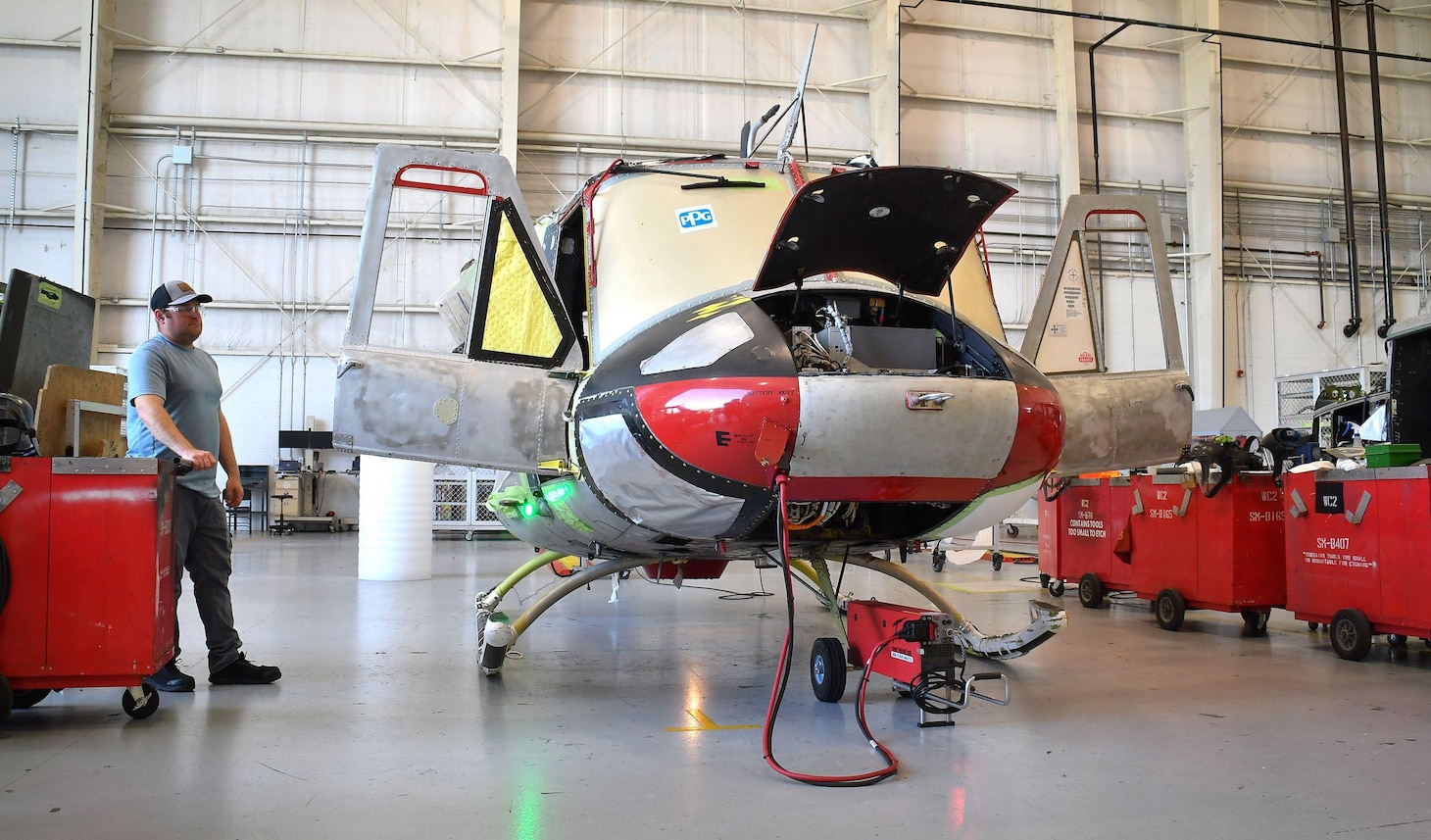 Sean Maher, an aircraft electrician on Fleet Readiness Center East’s (FRCE) UH-1N production line, utilizes a battery-powered generator while conducting checks on a UH-1N helicopter.