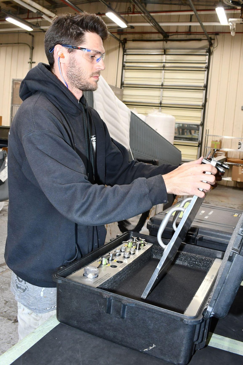 Michael Wells, a sheet metal worker in the H-53 Aircraft Components Shop at Fleet Readiness Center East (FRCE), prepares a plate used to check an H-53 spar fitting’s mount feet for excessive gaps.