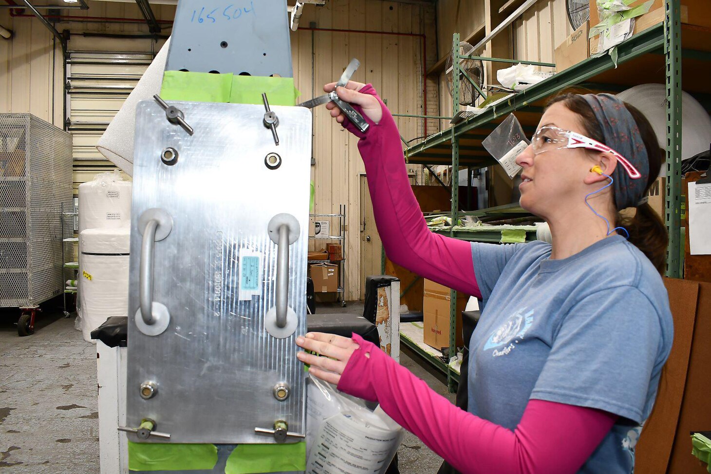 Shevaun Jones, a sheet metal worker in the H-53 Aircraft Components Shop at Fleet Readiness Center East (FRCE), uses a feeler gauge to check for excessive gaps on the mount feet of an H-53 spar fitting. The gap check is one step in a new procedure developed and refined by a team of artisans and engineers at FRCE in order to improve the manner in which the aircraft’s spar fittings are evaluated for fit, resulting in a higher acceptance rate and faster turnaround times for the components.