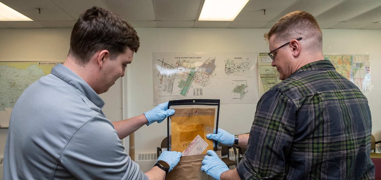 NCIS personnel sort through evidence from cold cases.