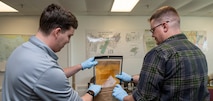 NCIS personnel sort through evidence from cold cases.