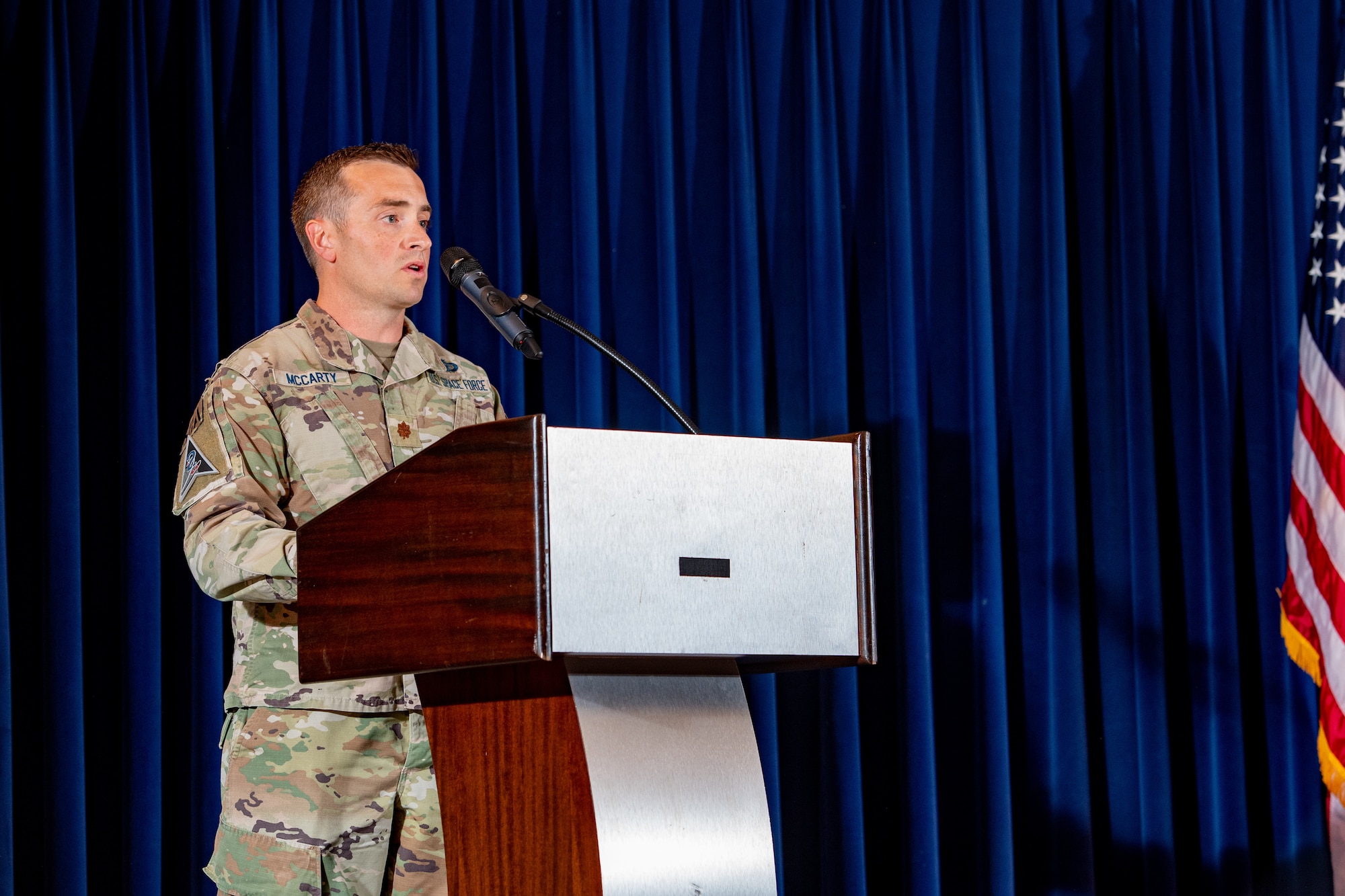 Man in military uniform speaking at podium
