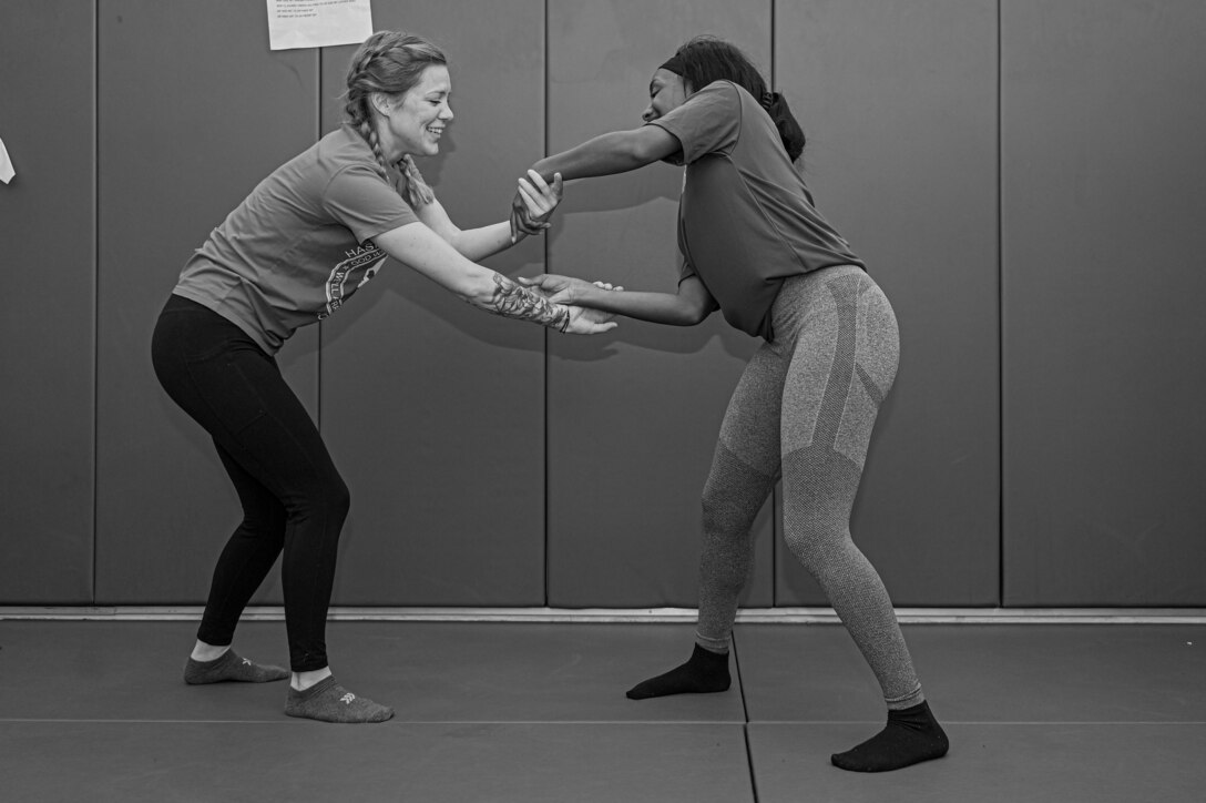 Photo of two participants practicing controlling techniques. Photo in black and white.
