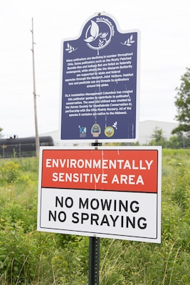 A sign in front of a prairie.