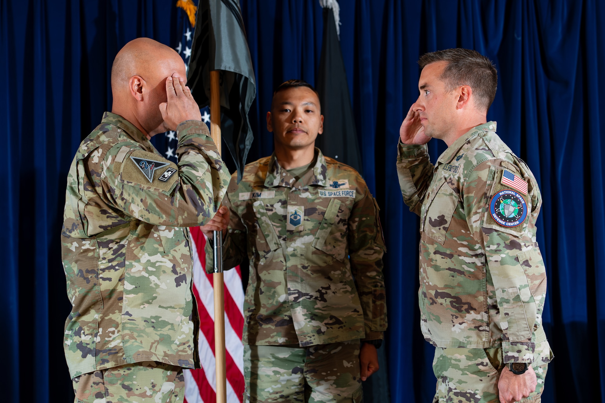 A man in military uniform salutes another man in military uniform