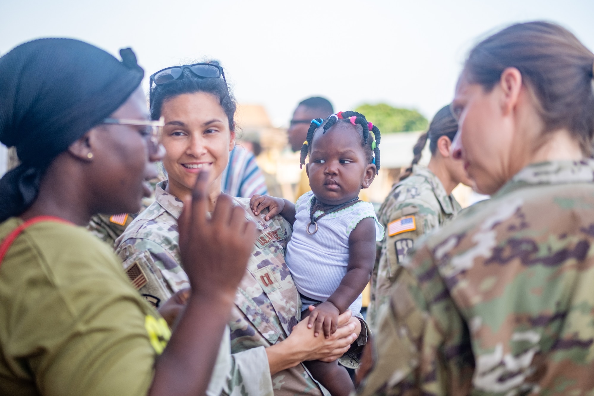 U.S. Air Force Capt. Sabrina Torres, a clinical nurse, assigned to 71st Medical Group, Special Operations Command holds a Ghanaian child while participating in the Boresah Royal Foundations city clean up at Flintlock 24 in Daboya, Ghana, May 21, 2024. Exercise Flintlock is U.S. Africa Command's premier and largest annual special operations exercise that strengthens key partner nations throughout Africa, in partnership with other international special operations forces. (U.S. Army National Guard photo by Spc. Kevin Brown)