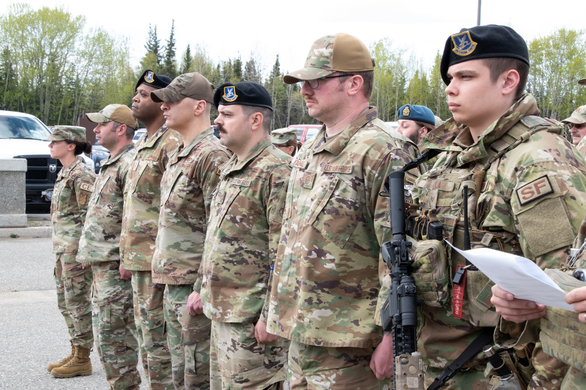 U.S. Space Force Guardians, U.S. Air National Guard Airmen, Canadian military members, and civilian firefighters serving at Clear Space Force Base, Alaska, stand in formation during the closing ceremony of National Police Week.