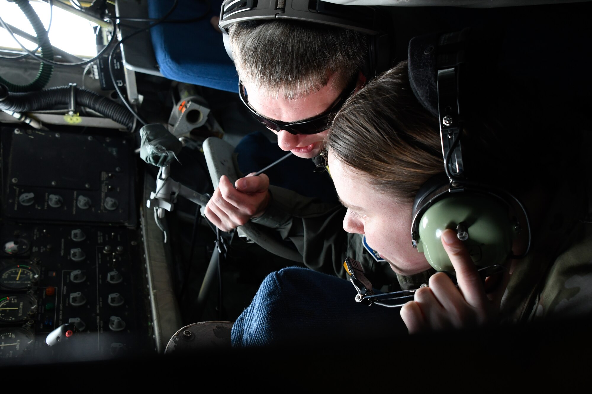 U.S. Air Force Master Sgt. Dan Kaufmann, a 168th Wing boom operator, teaches Capt. Turner MacPhee, 354th Medical Group, physical therapist, how to operate a boom for in-flight refueling on board a KC-135 Stratotanker.