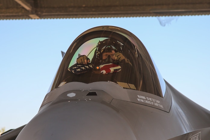 U.S. Marine Corps Lt. Col. Robert Guyette, an F-35B Lightning II pilot and commanding officer of Marine Fighter Attack Squadron (VMFA) 214, Marine Aircraft Group 13, 3rd Marine Aircraft Wing, places an American flag and an Australian flag in the cockpit of a Royal Australian Air Force F-35A Lightning II aircraft assigned to RAAF No. 75 Squadron before a bilateral training flight at RAAF Base Tindal, Northern Territory, Australia, June 20, 2024.