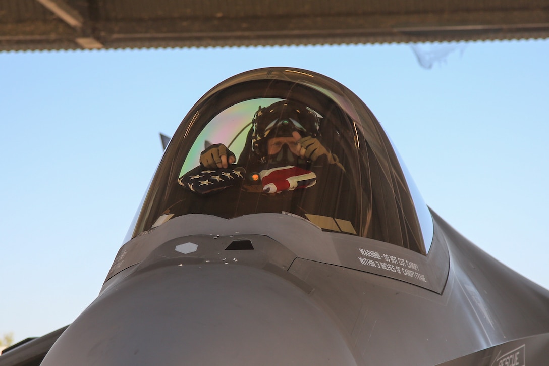 U.S. Marine Corps Lt. Col. Robert Guyette, an F-35B Lightning II pilot and commanding officer of Marine Fighter Attack Squadron (VMFA) 214, Marine Aircraft Group 13, 3rd Marine Aircraft Wing, places an American flag and an Australian flag in the cockpit of a Royal Australian Air Force F-35A Lightning II aircraft assigned to RAAF No. 75 Squadron before a bilateral training flight at RAAF Base Tindal, Northern Territory, Australia, June 20, 2024. Leaders with VMFA-214, a USMC F-35B squadron, flew the RAAF F-35A during bilateral training, exhibiting interchangeability between RAAF and U.S. Marine aviation. VMFA-214 deployed more than 200 Marines and eight F-35B Lightning II aircraft from Marine Corps Air Station Yuma, Arizona, to RAAF Base Tindal, Australia, to conduct bilateral training with the RAAF No. 3 Squadron and No. 75 Squadron. (U.S. Marine Corps photo by Cpl. Nicholas Johnson)
