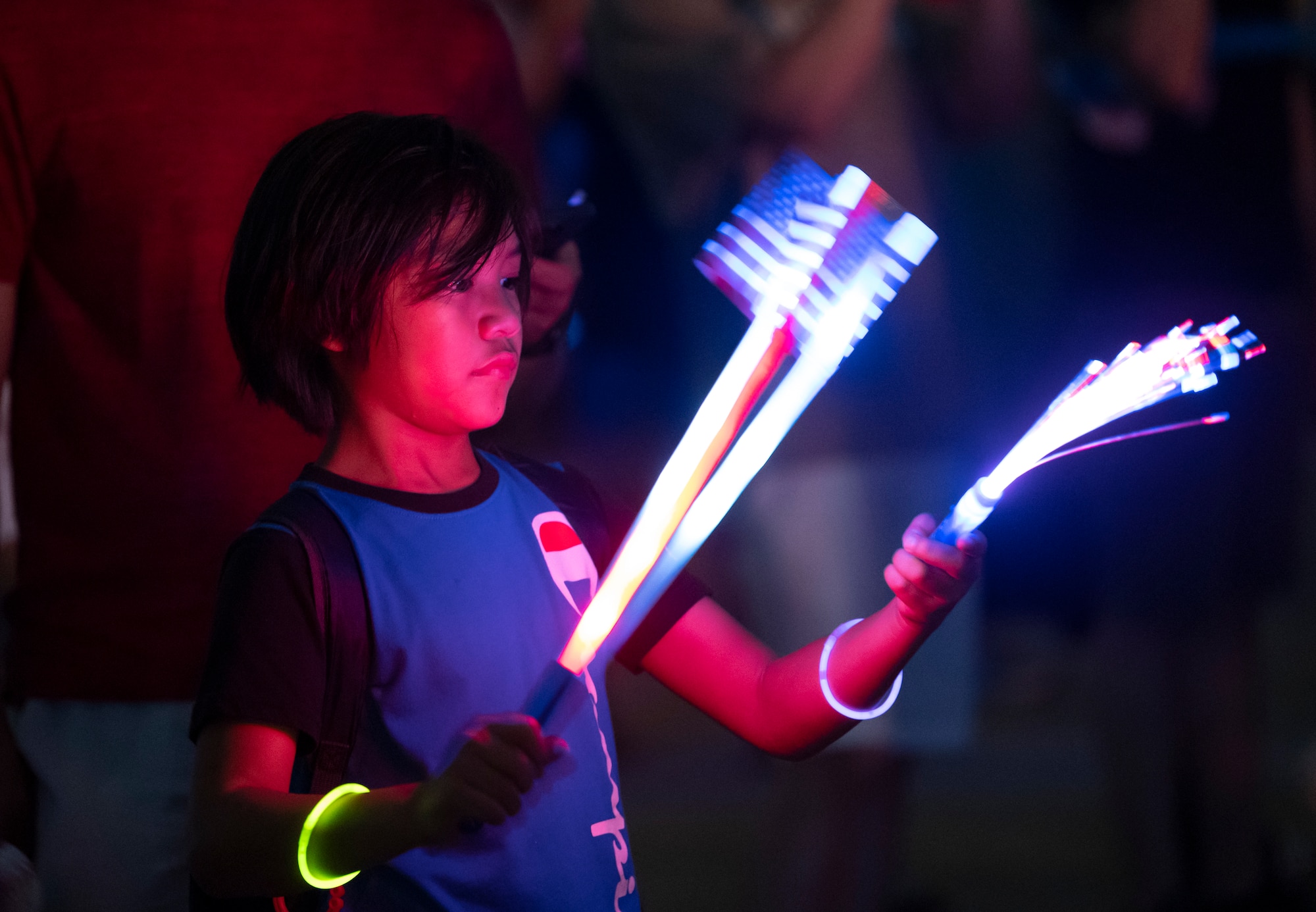 A military child plays with glow sticks during the fireworks show at the end of Liberty Fest at Osan Air Base, Republic of Korea, July 4, 2024. The 51st Force Support Squadron hosted the Liberty Fest to celebrate Independence Day for families stationed in the ROK. (U.S. Air Force photo by Staff Sgt. Ashley N. Mikaio)