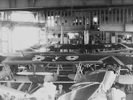Several Boeing F2B-1 fighters crowd the hangar deck of the USS Langley (CV-1) circa 1928. Early black-and-white film did not show several insignia colors properly, hence the blue of the national insignia’s circle on the wings became a light gray, while the dark red circle in the middle of the white star showed up as black.