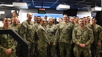 NORFOLK, Va. (June 17, 2024) Capt. Riley Murdock, commanding officer of Surface Combat Systems Training Command Hampton Roads, and students from the nine-week Aegis Tactical Action Officer course pose for a group photo during the Reconfigurable Combat Information Center Trainer ribbon cutting onboard Naval Station Norfolk.  (U.S. Navy photo by Electronics Technician 1st Class Cassondra Johnson)