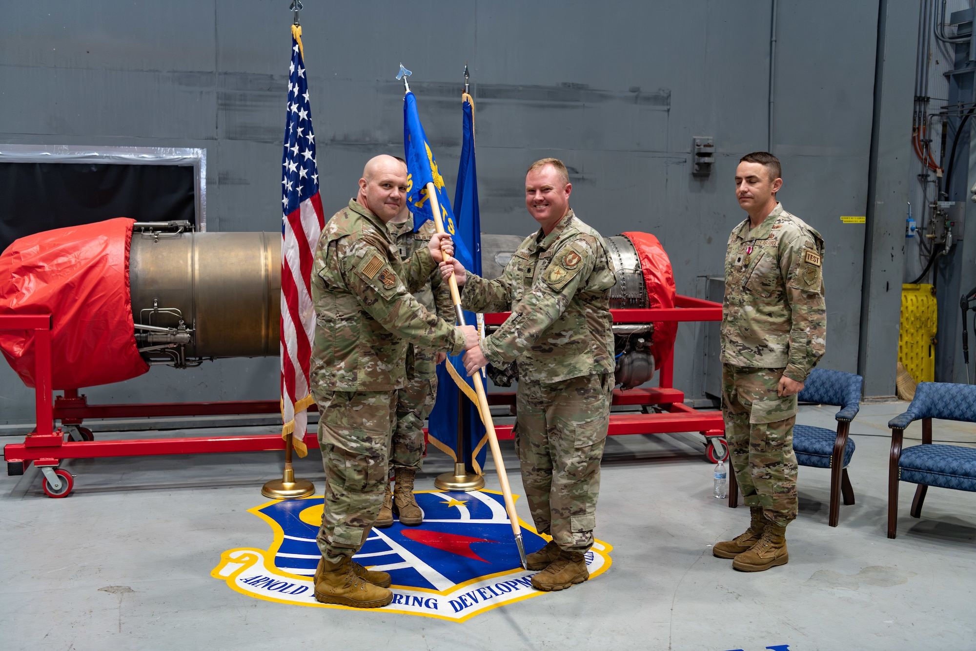 Lt. Col. Joshua Thomas, right center, takes the guidon from Arnold Engineering Development Complex 804th Test Group Commander Col. Jason Vap, left, to assume command of the AEDC 717th Test Squadron during a Change of Command ceremony June 27, 2024, at Arnold Air Force Base, Tenn., headquarters of AEDC. Also pictured is outgoing 717 TS commander Lt. Col. Ryne Roady, right. (U.S. Air Force photo by Keith Thornburgh)