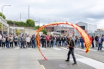 Minh Tran, Puget Sound Naval Shipyard & Intermediate Maintenance Facility Employee Resource Group program manager, performs a multicultural dragon flag dance June 27, 2024, during a Command "Pathway to Safety" training event outside Building 850, at the command in Bremerton, Wash. (U.S. Navy photo by Jeb Fach)