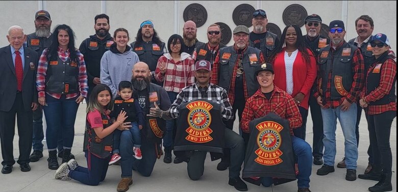 U.S. Marine Corps Gunnery Sgt. Christopher Goad, center, a powerline division chief with Marine Fighter Attack Squadron 314, Marine Aircraft Group 11, 3rd Marine Aircraft Wing, poses for a photo with members of the San Diego Chapter of the Marine Riders Iwo Jima motorcycle riding club, May 29, 2023. Goad, president of the VMFA-314 motorcycle riding club, was awarded the Navy and Marine Corps Commendation Medal for providing life-saving aid to a fellow motorcycle rider on April 21, 2024. (U.S. Marine Corps courtesy photo)