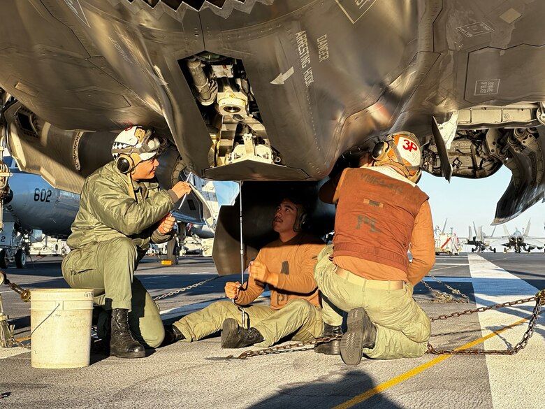 U.S. Marine Corps Gunnery Sgt. Christopher Goad, right, a powerline division chief with Marine Fighter Attack Squadron 314, Marine Aircraft Group 11, 3rd Marine Aircraft Wing, and Marines with VMFA 314, conduct maintenance on an F-35B Lightning II aircraft, aboard the Nimitz-class aircraft carrier USS Abraham Lincoln (CVN-72), February 11, 2024.  Goad, president of the VMFA-314 motorcycle riding club, was awarded the Navy and Marine Corps Commendation Medal for providing life-saving aid to a fellow motorcycle rider on April 21, 2024. (U.S. Marine Corps courtesy photo)