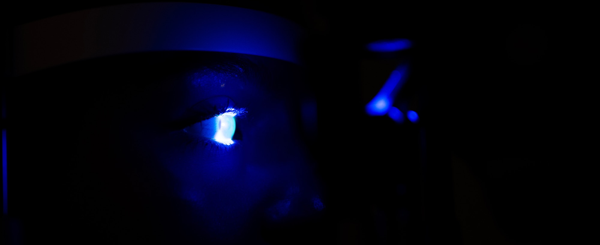 Airman 1st Class Jennifer Vannostrand, 5th Operational Medical Readiness Squadron optometry technician, receives a fluorescein evaluation at Minot Air Force Base, North Dakota, June 28, 2024. Fluorescein is used to assist in the detection of debris and corneal abrasions and the blue light helps identify and highlight any tears in the tissue. (U.S. Air Force photo by Airman 1st Class Alyssa Bankston)