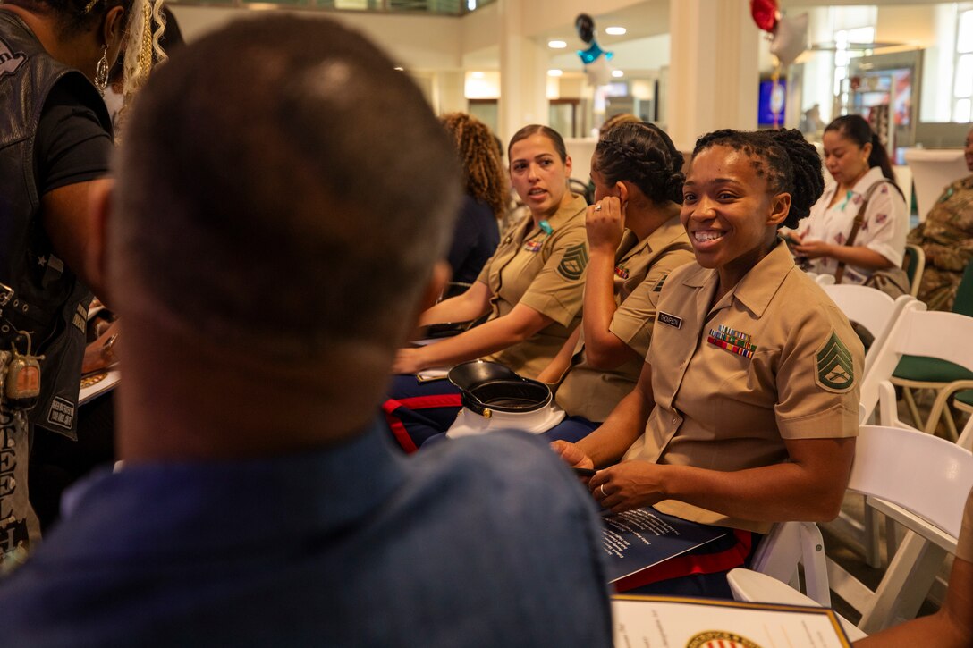 U.S. Marines Corps Staff Sgt. Brittany Thompson, right foreground, a recruiter with Recruiting Sub Station Conroe, Recruiting Station Houston, speaks to an attendee at the Texas Women Veteran's Day Ceremony at City Hall, Houston, Texas, June 12, 2024. The ceremony served to honor female veterans and recognize the history of women in the armed services - with the ceremony sharing the same date as the 76th anniversary of the Women's Armed Services Integration Act. Thompson is a native of Washington, D.C. (U.S. Marine Corps photo by Sgt. Ryan H. Pulliam)