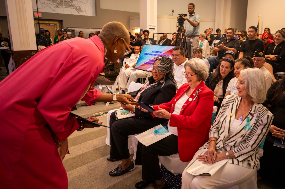 Camilla Thomas, center right, a Marine veteran and one of the honorees at the Texas Women Veteran's Day Ceremony, receives a gift at City Hall, Houston, Texas, June 12, 2024. The ceremony served to honor female veterans and recognize the history of women in the armed services - with the ceremony sharing the same date as the 76th anniversary of the Women's Armed Services Integration Act. (U.S. Marine Corps photo by Sgt. Ryan H. Pulliam)
