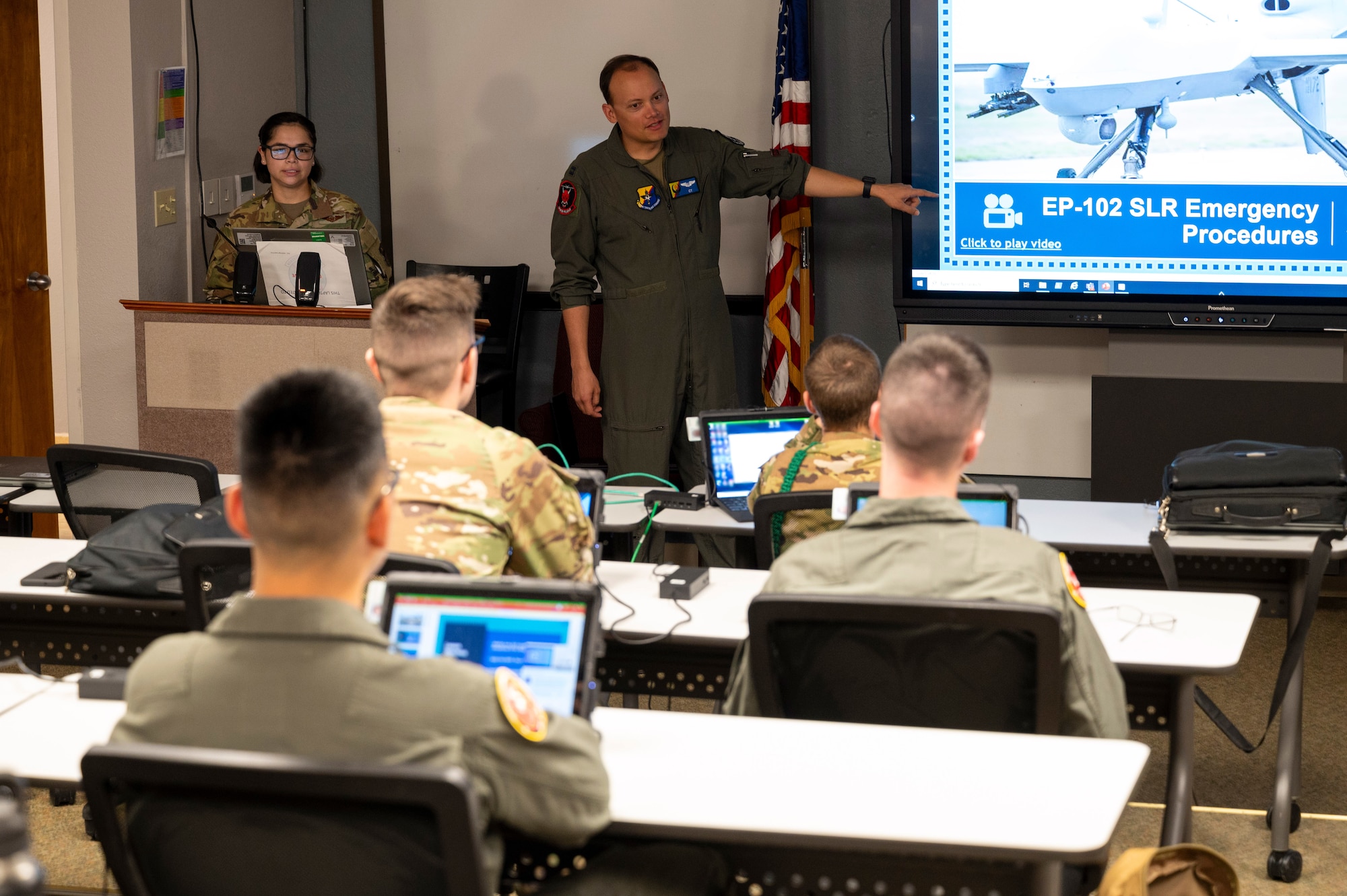 U.S. Air Force Capt. Eran East, 6th Attack Squadron instructor pilot, center, teaches a course on MQ-9 Reaper emergency procedures at Holloman Air Force Base, New Mexico, July 3, 2024.