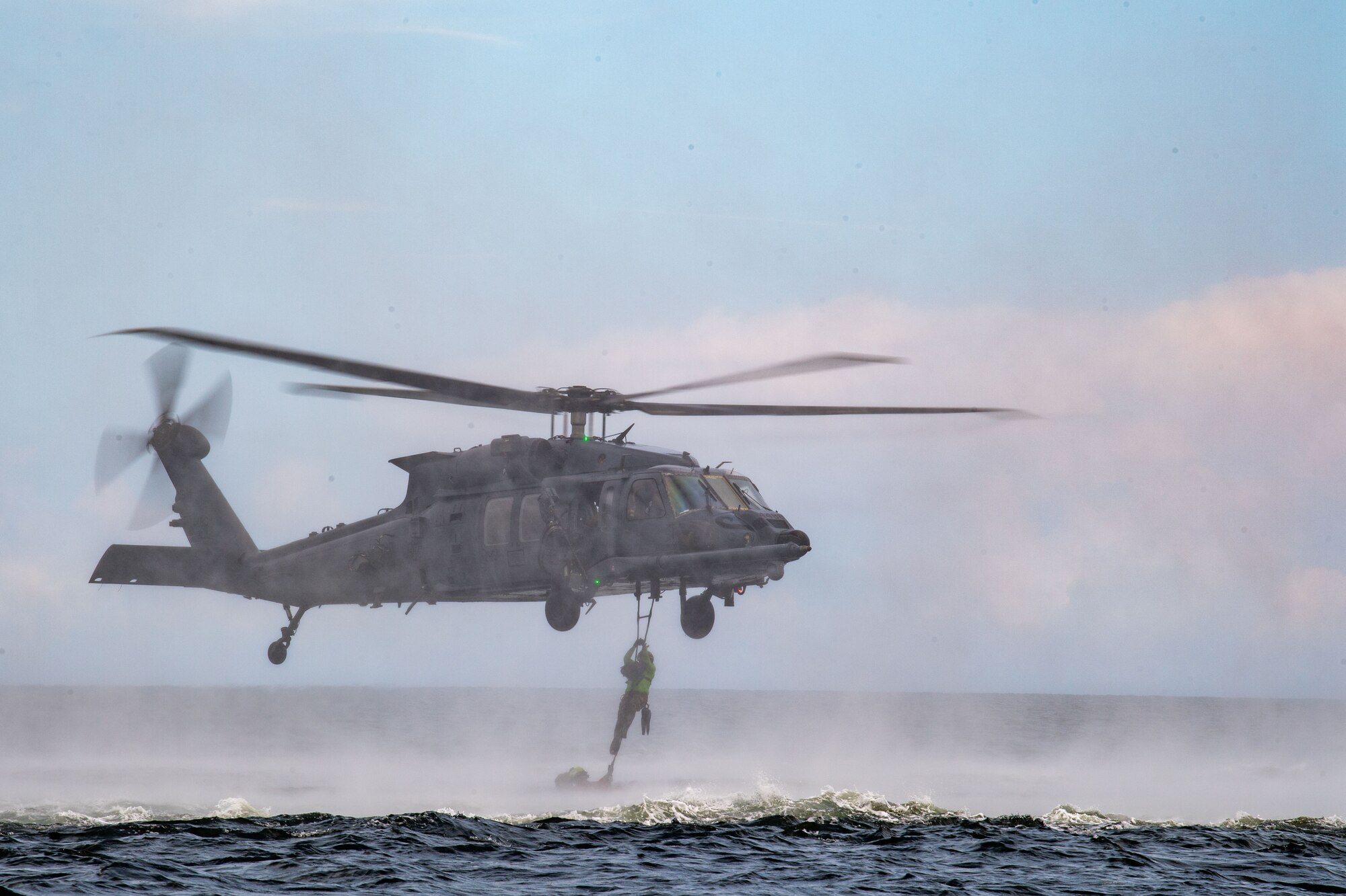 U.S. Air Force HH-60W Jolly Green II pilots hover at low altitude in preparation for a water operation exercise in the Gulf of Mexico, June 24, 2024. The HH-60W is designed from the ground up with integrated mission systems that improve situational awareness for aircrews conducting combat search and rescue missions in contested environments. The helicopters feature new multi-function displays to provide pilots with critical flight information. (U.S. Air Force photo by 2nd Lt. Benjamin Williams)