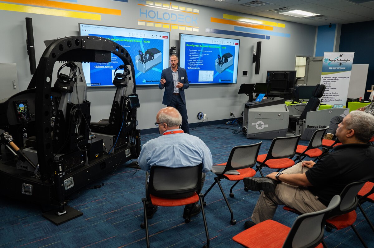 Scientist speaking to group about simulators.