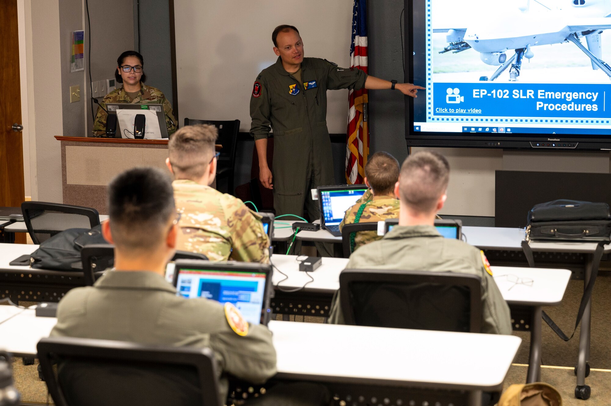 U.S. Air Force Capt. Eran East, 6th Attack Squadron instructor pilot, center, teaches a course on MQ-9 Reaper emergency procedures at Holloman Air Force Base, New Mexico, July 3, 2024.