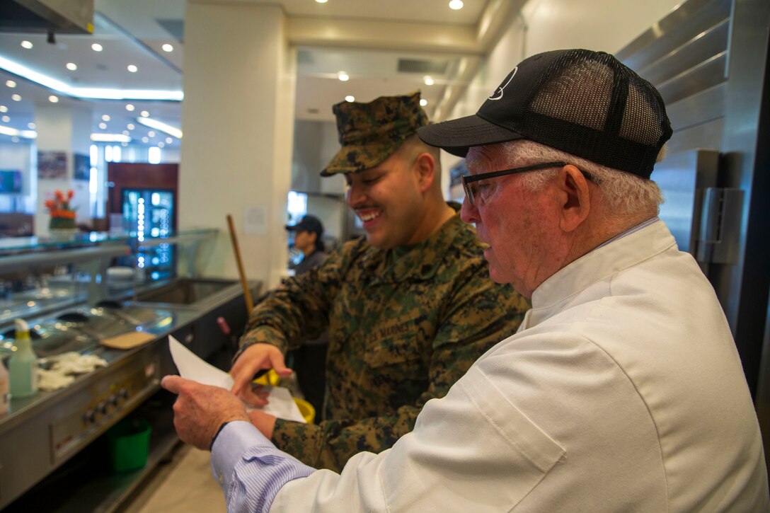 Sgt. Jose R. Sanchez, left, a food service specialist with Headquarters & Headquarters Squadron, Marine Corps Air Station Iwakuni, explains how equipment is inspected at the Flight Line Mess Hall to Mike Johnston, a member of the National Restaurant Association Education Foundation, as part of the Maj. Gen. William Pendleton Thompson (W.P.T.) Hill memorial awards program, MCAS Iwakuni, Japan, Jan. 29, 2024. The W.P.T. Hill awards program aims to acknowledge outstanding performance within Marine Corps food service operations, including determining and recognizing the best mess halls of the year.