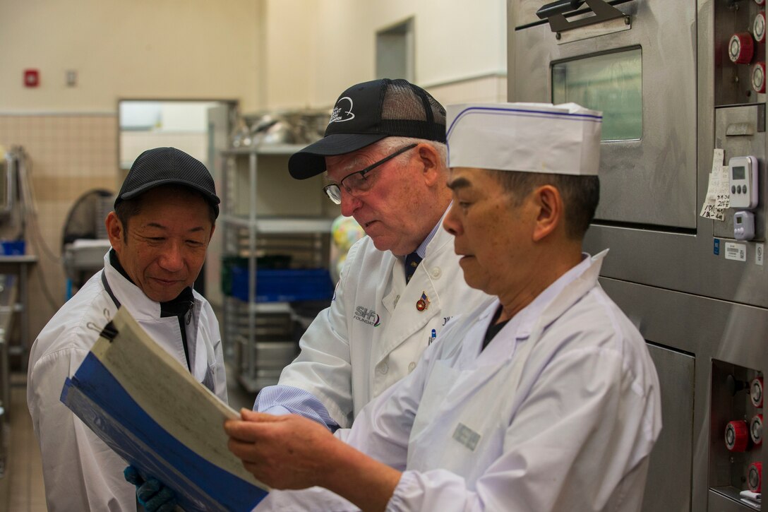 Mike Johnston, a member of the National Restaurant Association Education Foundation, inspects the baking recipes and procedures of the Flight Line Mess Hall at Marine Corps Air Station Iwakuni, Japan, as part of the Maj. Gen. William Pendleton Thompson (W.P.T.) Hill memorial awards program, Jan. 29, 2024. The W.P.T. Hill awards program aims to acknowledge outstanding performance within Marine Corps food service operations, including determining and recognizing the best mess halls of the year.