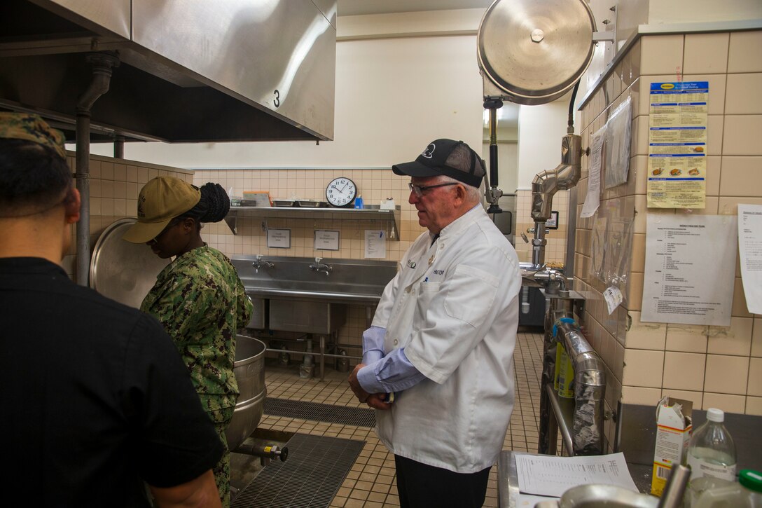 Mike Johnston, a member of the National Restaurant Association Education Foundation, inspects the preparation of ingredients at the Flight Line Mess Hall at Marine Corps Air Station Iwakuni, Japan, as part of the Maj. Gen. William Pendleton Thompson (W.P.T.) Hill memorial awards program, Jan. 29, 2024. The W.P.T. Hill awards program aims to acknowledge outstanding performance within Marine Corps food service operations, including determining and recognizing the best mess halls of the year.