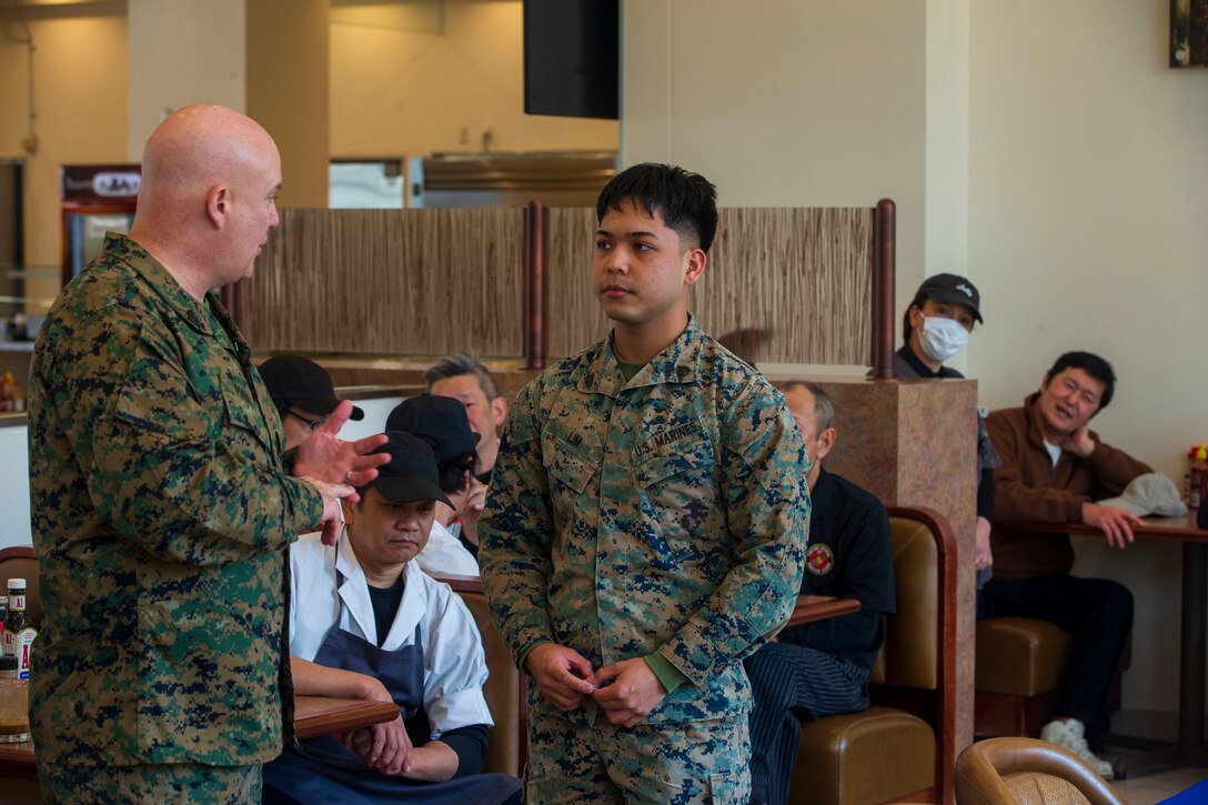 U.S. Marine Corps Master Gunnery Sgt. Brett Marks, left, the food services staff non-commissioned officer in charge for Marine Corps Installations Command, compliments Sgt. Lim Christian, a food service specialist with Headquarters and Headquarters Squadron, Marine Corps Air Station Iwakuni, after giving him a challenge coin for outstanding work while taking part in the Maj. Gen. William Pendleton Thompson (W.P.T.) Hill memorial awards program at MCAS Iwakuni, Japan, Jan. 29, 2024. The W.P.T. Hill awards program aims to acknowledge outstanding performance within Marine Corps food service operations, including determining and recognizing the best mess halls of the year.