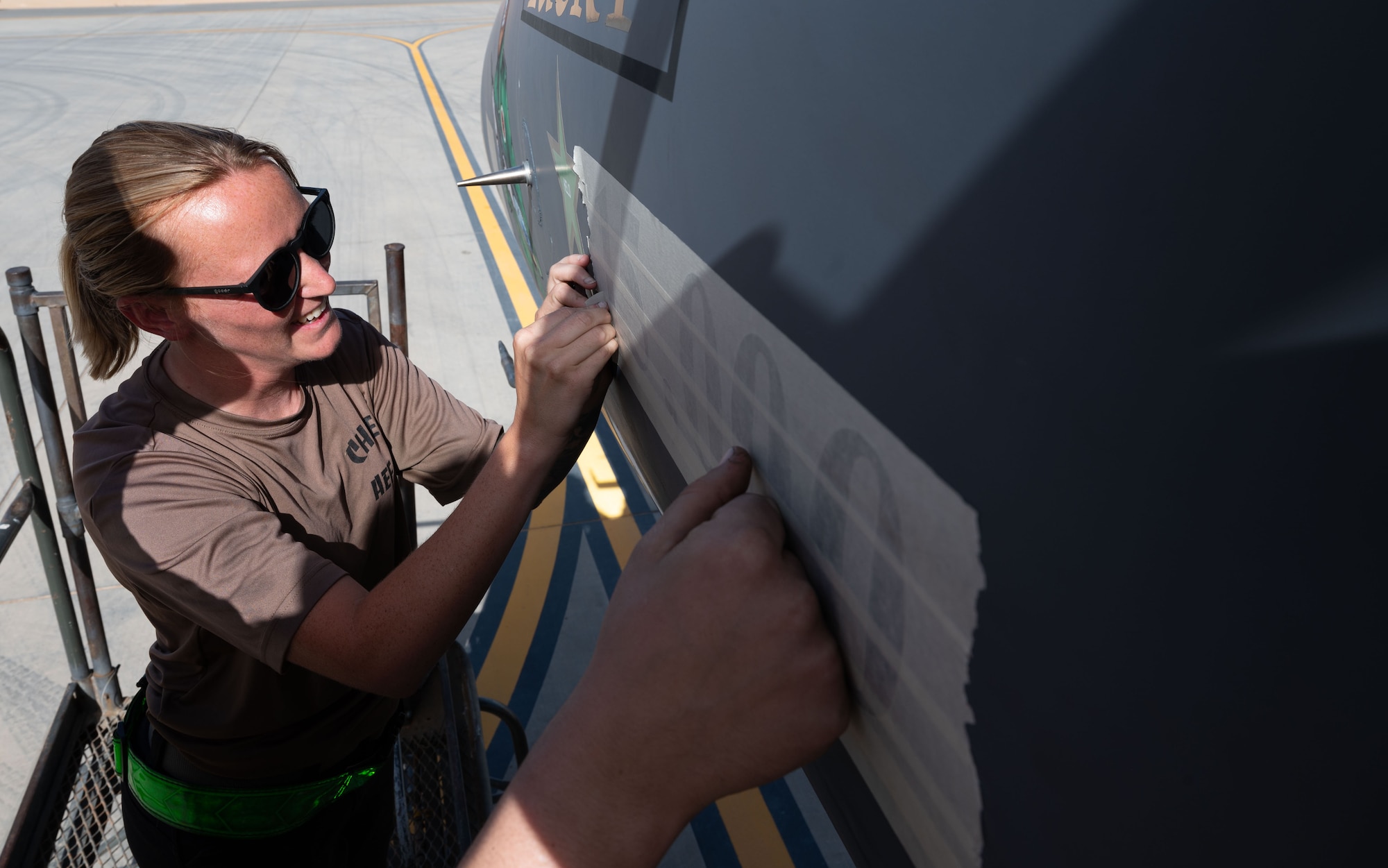 A U.S. Air Force 335th Expeditionary Fighter Generation Squadron crew chief places a “15,000” sticker on an F-15E Strike Eagle, at an undisclosed location in the U.S. Central Command area of responsibility, May 17, 2024. The first F-15E was delivered in April 1988, and very few fighter aircraft have achieved the major milestone of 15,000 flight hours.  The significance of achieving this milestone in a combat zone during a combat sortie highlights the U.S. Air Force’s ability to maintain high-end mission execution spanning generations. (U.S. Air Force photo)
