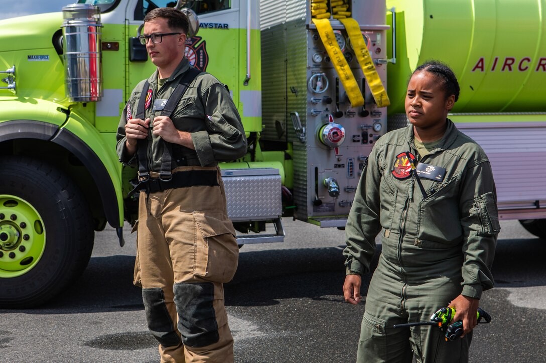 U.S. Marine Corps Cpl. Mason Sargent, the lead firefighter of Aircraft Rescue and Firefighting (ARFF), Headquarters and Headquarters Squadron (H&HS), Marine Corps Air Station Iwakuni, and a native of Nevada, and Sgt. Yasmine Huley-Morris, the station captain of ARFF, and a native of Virginia conduct a debrief after a simulated ARFF F-18 hot breaks, spontaneous combustion training exercise at MCAS Iwakuni, Japan, June 4, 2024. Huley-Morris recently received the Military Firefighter of the Year award for all military services. The award recognizes the firefighters accomplishments of the preceding year for setting the example of professional activities and career development goals. (U.S. Marine Corps photo by Lance Cpl. Dahkareo Pritchett)