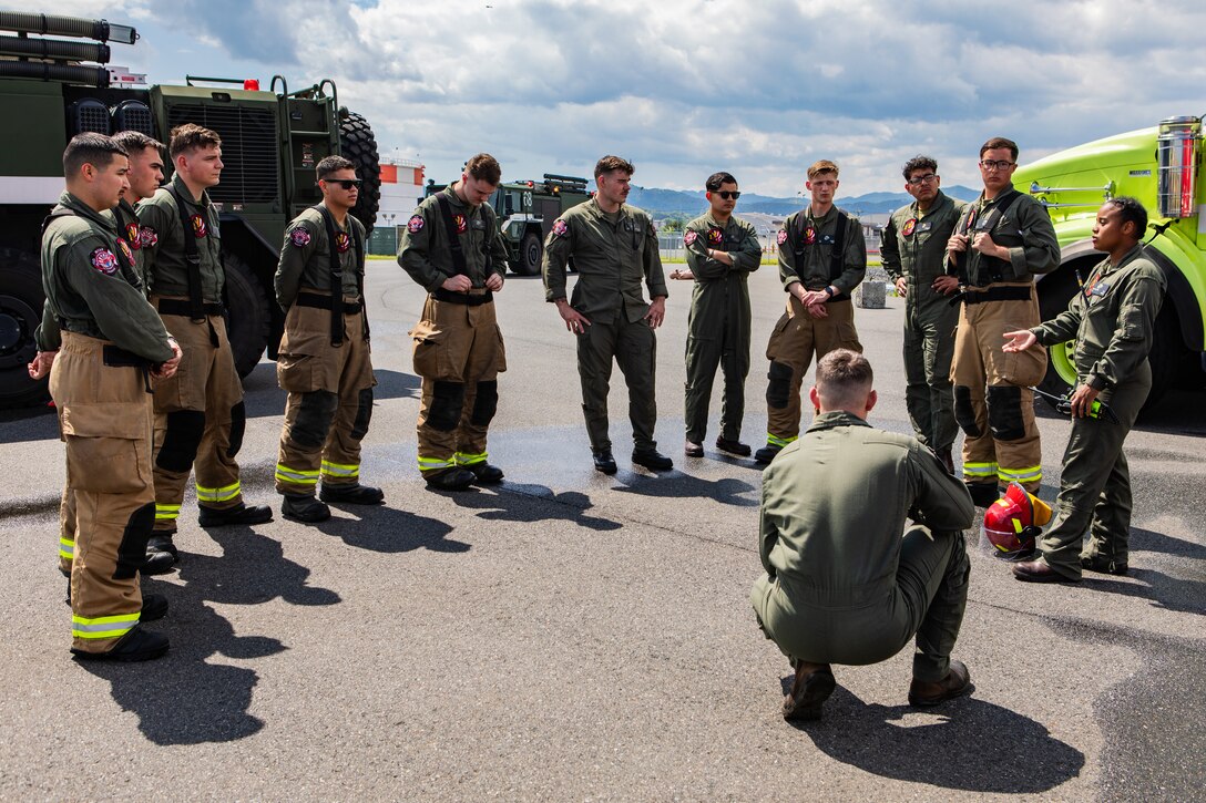 U.S. Marines with Aircraft Rescue and Firefighting (ARFF), Headquarters and Headquarters Squadron (H&HS), Marine Corps Air Station Iwakuni, conduct a debrief after a simulated ARFF F-18 hot breaks, spontaneous combustion training exercise at MCAS Iwakuni, Japan, June 4, 2024. Huley-Morris recently received the Military Firefighter of the Year award for all military services. The award recognizes the firefighters accomplishments of the preceding year for setting the example of professional activities and career development goals. (U.S. Marine Corps photo by Lance Cpl. Dahkareo Pritchett)