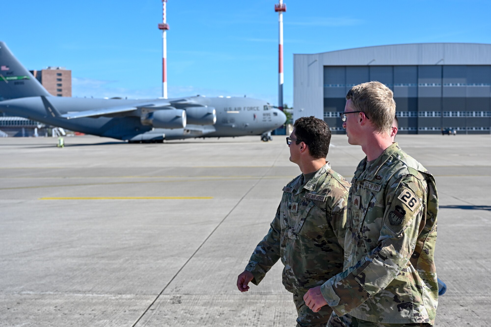 Cadet 2nd Class Eric Randall, center, and Cadet 2nd Class Noble Rasmussen, United States Air Force Academy cadets, gaze at a C-17 Globemaster III on the flightline at Ramstein Air Base, Germany, July 8, 2024.