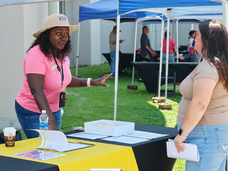 Brittany Hart from Commander, Fleet Activities Yokosuka Fleet and Family Support Center (CFAY FFSC) talks to a base community member signing up to participate in the installation's FFSC Career Fair June 14, 2024.