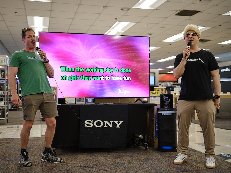 Capt. Les Sobol (right) and Cmdr. Patrick Gutierrez (left), Commander, Fleet Activities Yokosuka's commanding officer and chief staff officer respectively, sing "Girls Just Want to Have Fun" at the Navy Exchange Yokosuka Karaoke Roadshow June 14, 2024.