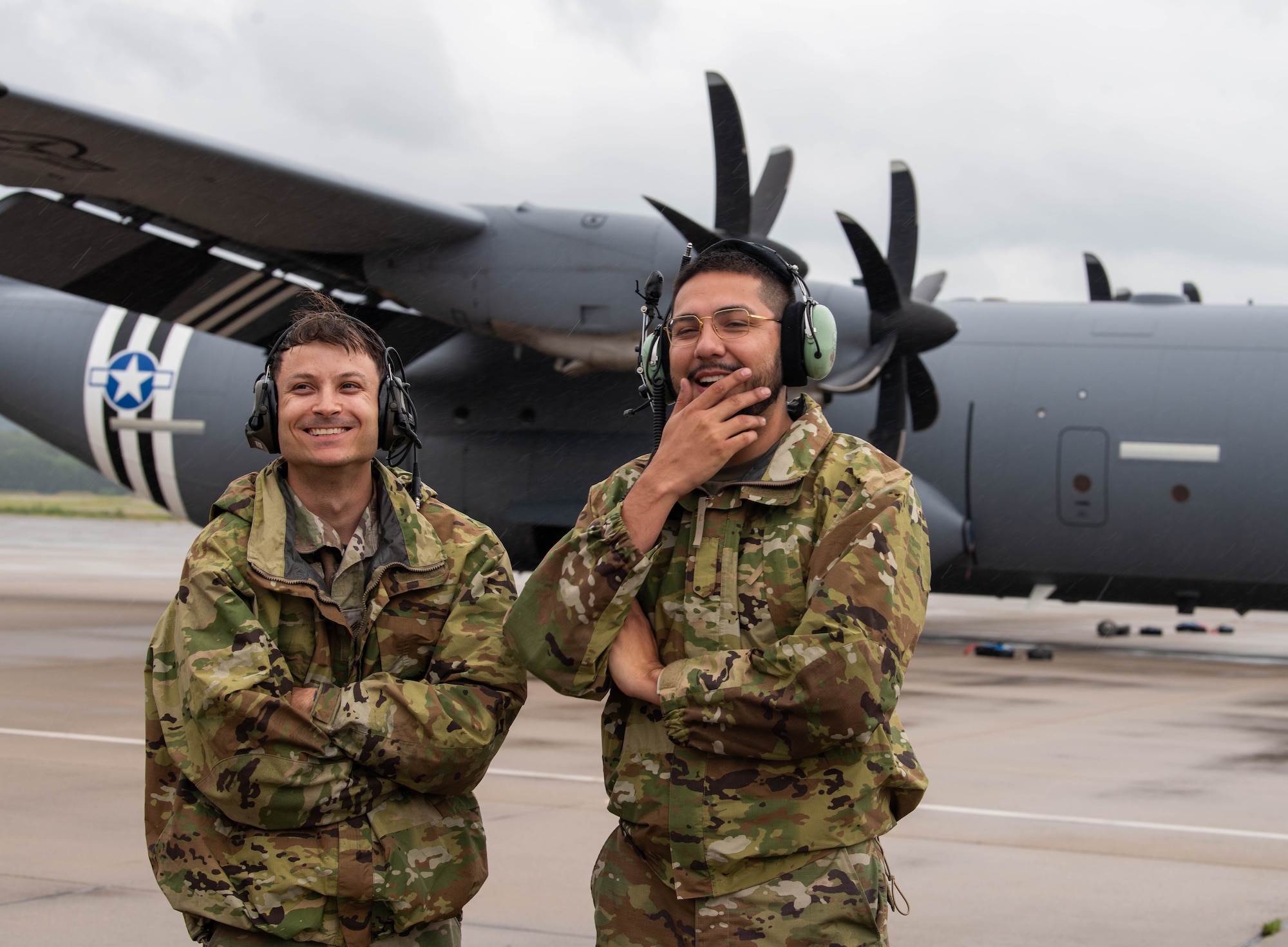 Airmen stand in front of aircraft.