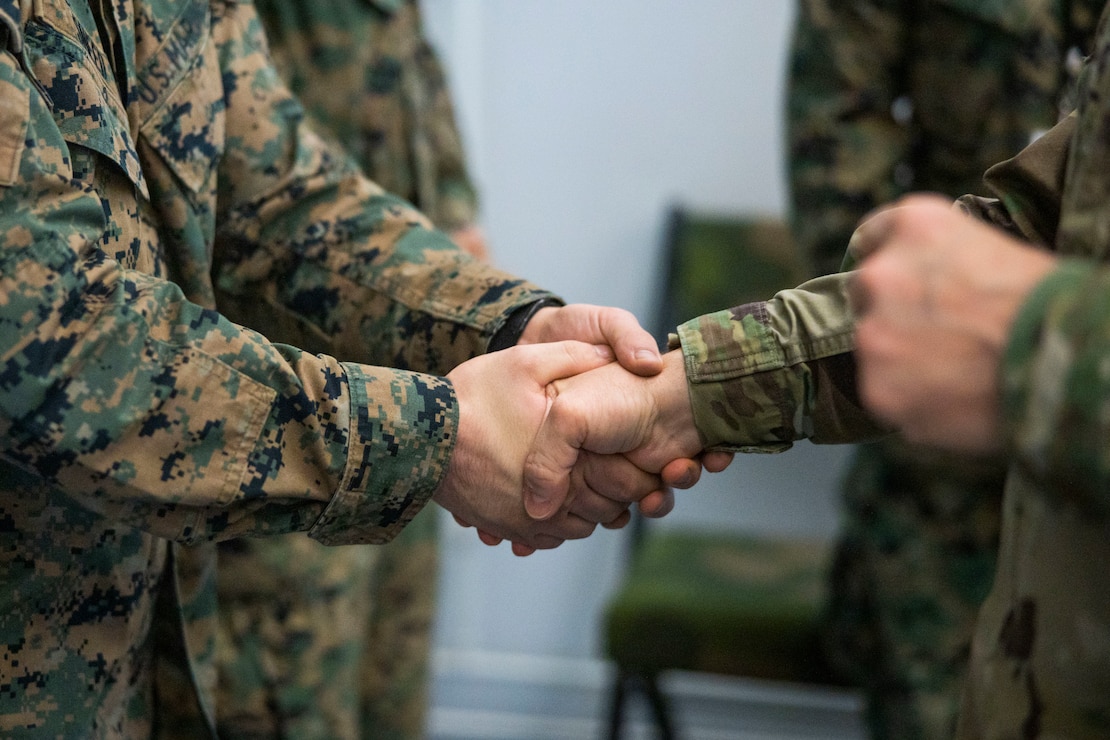 U.S. Army Maj. Gen. John H. Phillips, the U.S. European Command's Command, Control, Communications, Computers and Cyber Director (J-6) gives a coin to a U.S. Marine with 8th Communications Battalion, II Marine Expeditionary Force (MEF) Information Group at Bardufoss, Norway, Feb. 27, 2024. The J-6 is a joint staff section responsible for command, control, communications and computer systems and provides commanders with the ability to make and communicate timely decisions across their areas of operations. II MEF Marines are participating in exercise Nordic Response 24 which is a Norwegian national readiness and defense exercise designed to enhance military capabilities and allied cooperation. This exercise will test military activities ranging from the reception of allied and partner reinforcements and command and control interoperability to combined joint operations, maritime prepositioning force logistics, integration under challenging Arctic conditions, in high-intensity warfighting including rugged terrain and extreme cold weather with NATO militaries, and reacting against an adversary force during a dynamic training environment. (U.S. Marine Corps photo by Cpl. Jacquilyn Davis)