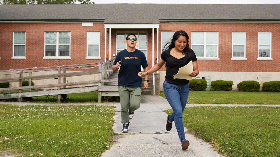 U.S. Marine Corps Gunnery Sgt. Vincent Song, left, a transmissions chief, and Cpl. Ana Perezaguilar, right, a radio operator, with 8th Communication Battalion, II Marine Expeditionary Force (II MEF), review a clue on their way ro the next station during the Sexual Assault Prevention and Response (SAPR) scavenger hunt, on Marine Corps Base Camp Lejeune, North Carolina, April 26, 2024. The scavenger hunt was a collaborative event, used to inform Marines about SAPR related resources available on base. (U.S. Marine Corps photo by Cpl. Emily Hazelbaker)