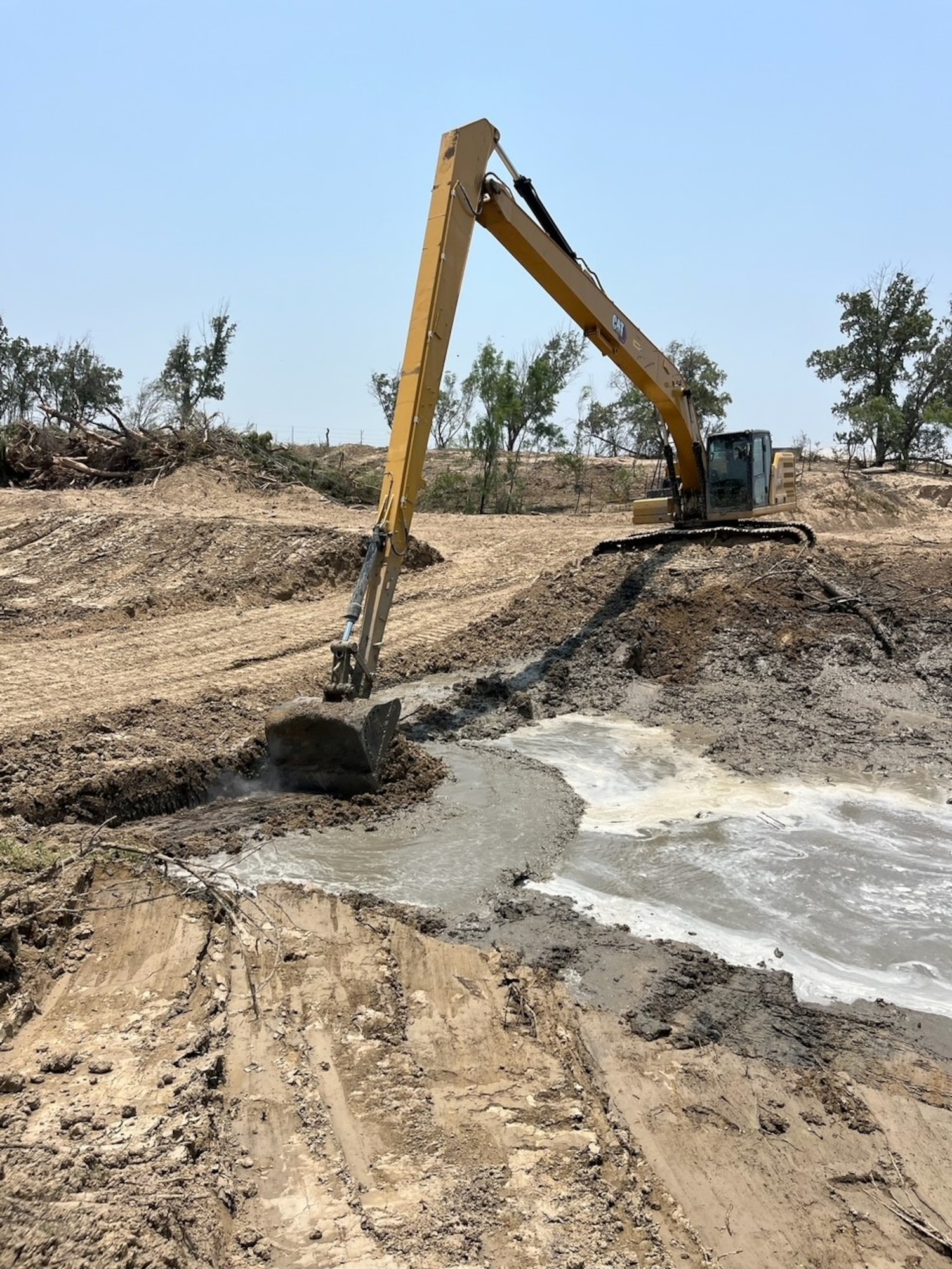 U.S. Airmen assigned to the 202nd RED HORSE Squadron construct a water outlet spanning approximately 1.5 miles on Fronton Island, Texas, in support of Operation Lone Star, April 29 - May 31. Their goal was to aid Texas in reducing illegal drug and immigration trafficking by restricting the movement of known cartel groups in one of the most contested and dangerous areas on the U.S.-Mexico border. (Courtesy photo) (This image was edited to exclude a member's name due to operational security considerations.)