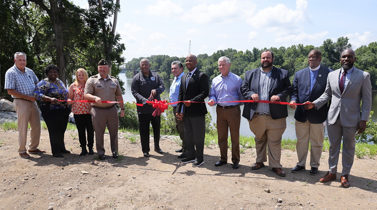 Several people at a ribbon cutting.