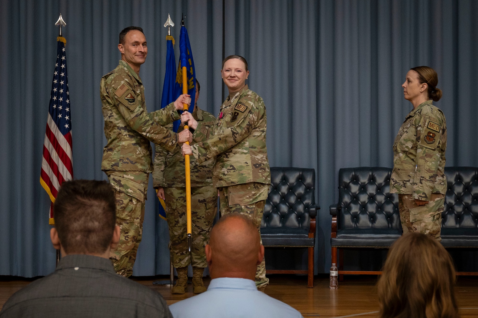 U.S. Air Force Col. Angela Lacek (middle), former 47th Medical Group (MDG) commander, turns over the 47th MDG guidon to Col. Tyler Ellison (left), 47th Flying Training Wing (FTW) commander, during the 47th MDG change of command ceremony at Laughlin Air Force Base, Texas, July 9, 2024. As commander of the 47th MDG, Lacek led 145 Airmen, civilians and contractors who support the 47th FTW by ensuring the medical readiness and health care of 1,500 Active Duty, 400 Reservists and 3,200 additional beneficiaries. (U.S. Air Force photo by Senior Airman Kailee Reynolds)