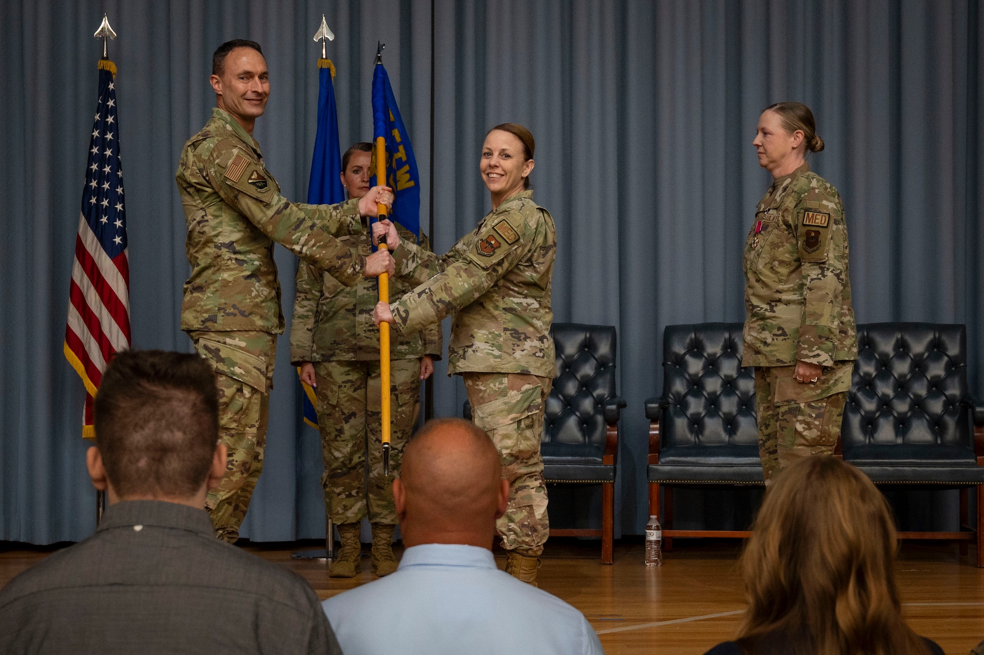 U.S. Air Force Col. Kelly Vermillion (middle), 47th Medical Group (MDG) commander, accepts the 47th MDG guidon from Col. Tyler Ellison (left), 47th Flying Training Wing (FTW) commander, during the 47th MDG change of command ceremony at Laughlin Air Force Base, Texas, July 9, 2024. As commander of the 47th MDG, Vermillion will lead 145 Airmen, civilians and contractors who support the 47th FTW by ensuring the medical readiness and health care of 1,500 Active Duty, 400 Reservists and 3,200 additional beneficiaries. (U.S. Air Force photo by Senior Airman Kailee Reynolds)
