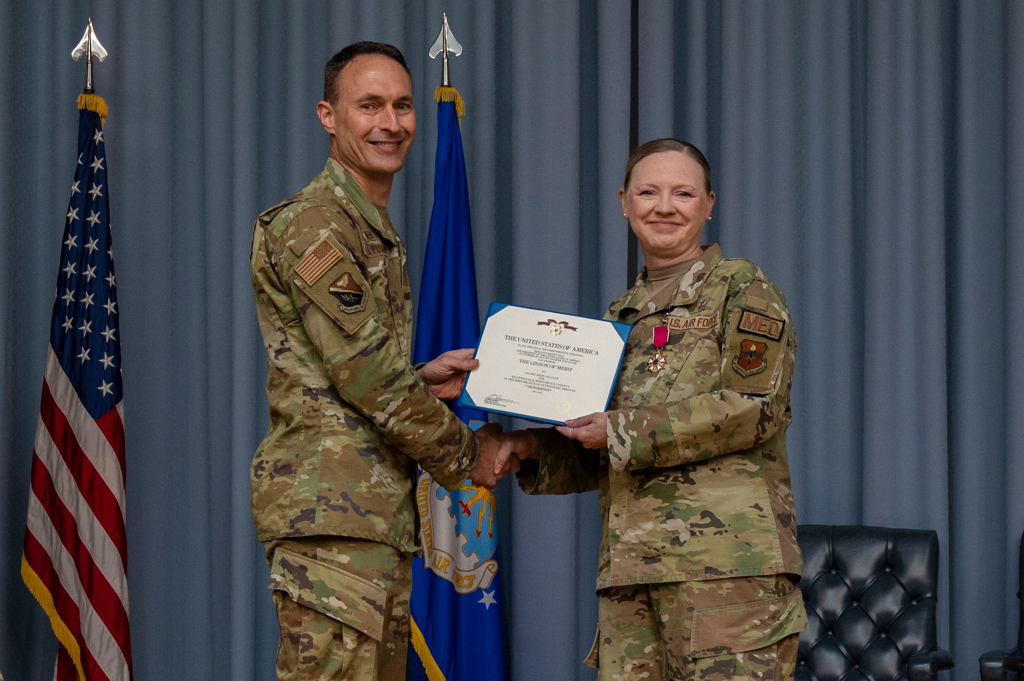 U.S. Air Force Col. Ellison (left), 47th Flying Training Wing (FTW) commander, presents the Legion of Merit to Col. Angela Lacek (right), former 47th Medical Group (MDG) commander, during the 47th MDG change of command ceremony at Laughlin Air Force Base, Texas, July 9, 2024. As the commander of the 47th MDG, Lacek led 145 Airmen, civilians and contractors who support the 47th FTW by ensuring the medical readiness and health care of 1,500 Active Duty, 400 Reservists and 3,200 additional beneficiaries. (U.S. Air Force photo by Senior Airman Kailee Reynolds)