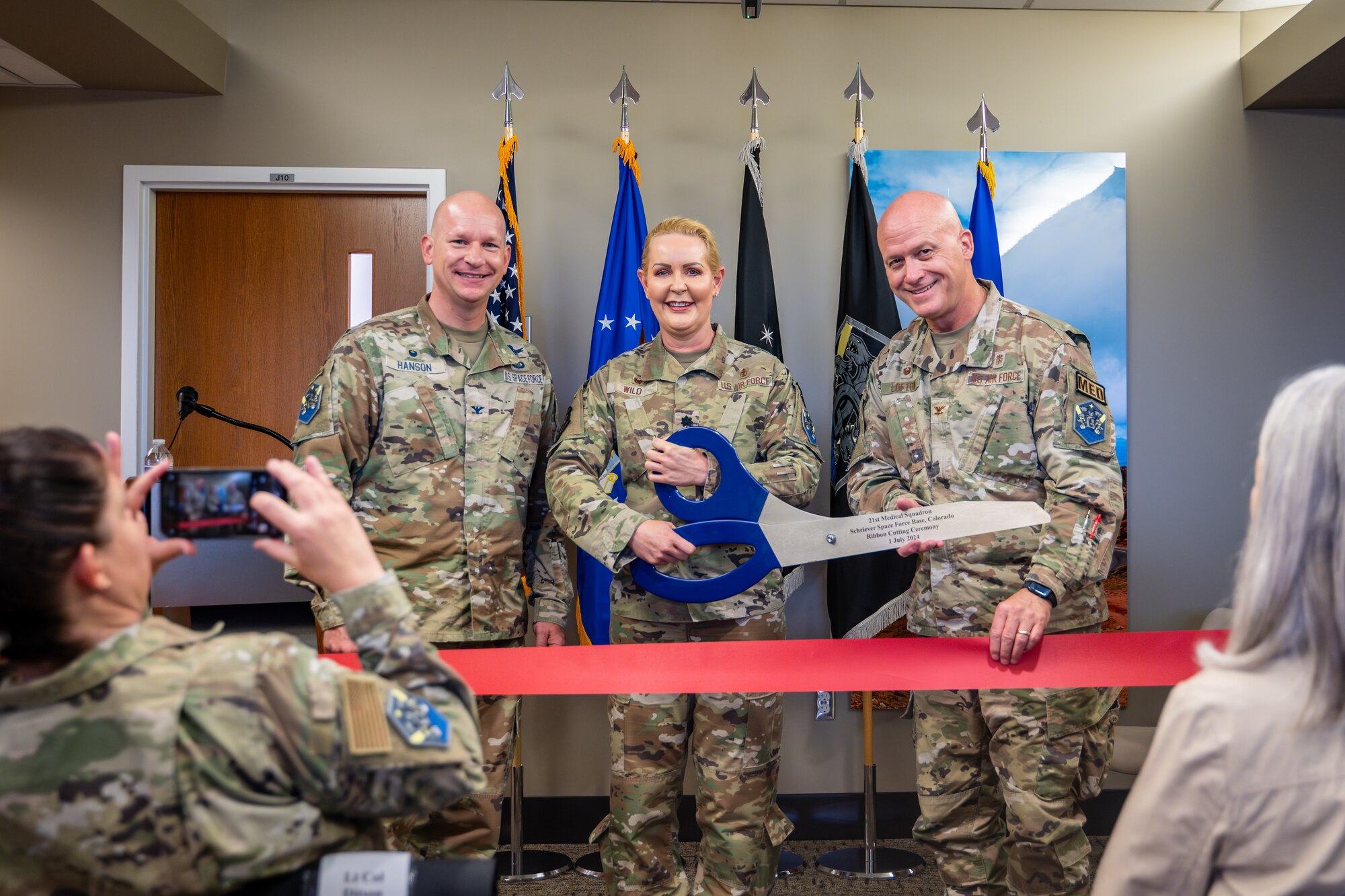 From left, U.S. Space Force Col. David Hanson, Space Base Delta 1 commander, U.S. Air Force Lt. Col. Elaina Wild, 21st Medical Squadron commander, and U.S. Air Force Col. Donald Lofton, 21st Medical Group commander, perform a ribbon cutting ceremony for the new medical clinic at Schriever Space Force Base, Colorado, July 1, 2024. Military bases must have medical facilities to ensure the health and well-being of their personnel and families. With a growing base, these improvements are geared toward increasing operational readiness and overall quality of life for the community at Schriever SFB. (U.S. Space Force photo by Dalton Prejeant)