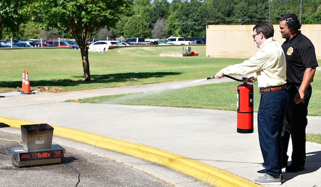 Frank Goodwin, U.S. Army Space and Missile Defense Command archive technician, learns how to properly use a fire extinguisher from Staunchis Williams, Redstone Arsenal Fire Department fire inspector, during the command’s Safety Awareness Day at its Redstone Arsenal, Ala., headquarters on June 25. (U.S. Army photo by Jason B. Cutshaw)