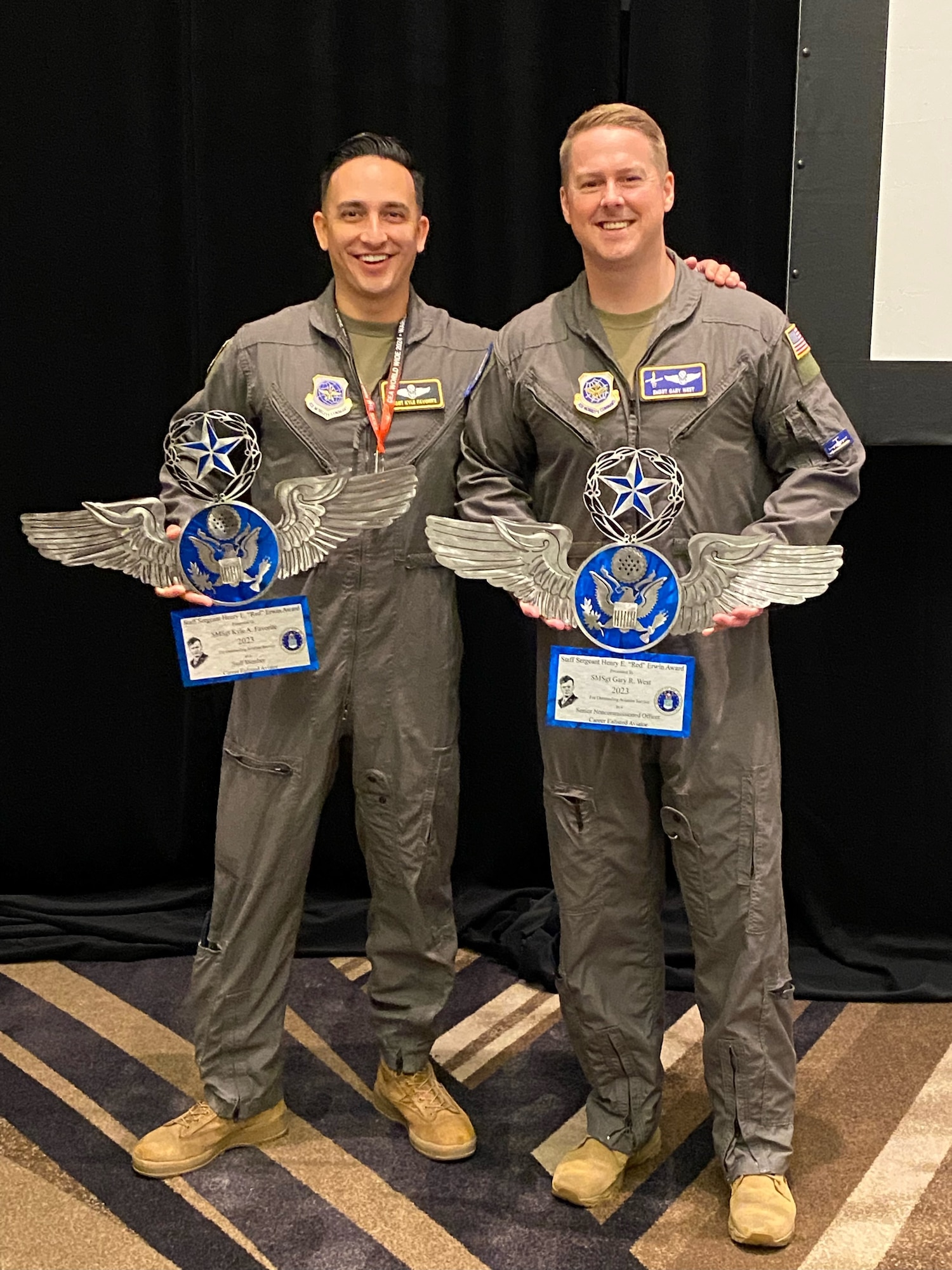 U.S. Air Force Senior Master Sgt. Kyle Favorite, 62d Operations Group standardization and evaluation superintendent, left, and Senior Master Sgt. Gary West, 7th Airlift Squadron senior enlisted leader, hold their Staff Sgt. Henry E. “Red” Erwin awards at the Career Enlisted Aviator Worldwide Working Group conference in Dallas, Texas, July 9, 2024.